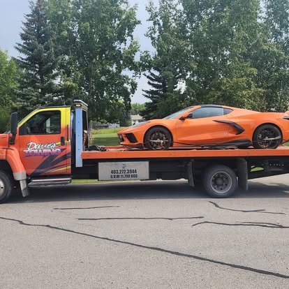 Dave's Towing flatbed truck towing a sports car in Vulcan